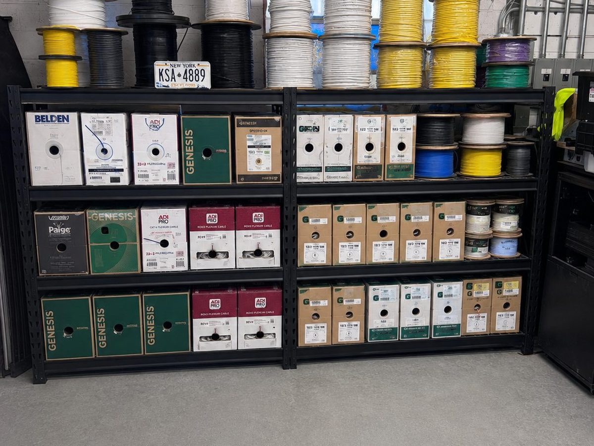 Warehouse shelving stocked with cameras, recorders, panels and devices at Tri-State Technologies in Freeport, NY